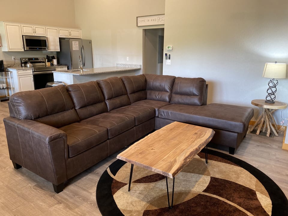 Open floor plan with comfortable sectional, chair, fireplace and Roku smartTV.