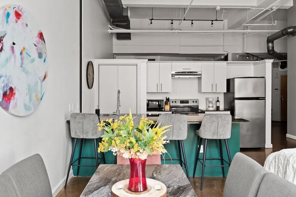 Dining setup with modern touch ✅ Caption: Enjoy your meals at this stylish dining table with a vibrant centerpiece.