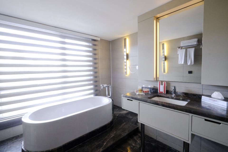 Suite, 1 King Bed with Sofa bed, Non Smoking | Bathroom | Rainfall showerhead, free toiletries, hair dryer, slippers