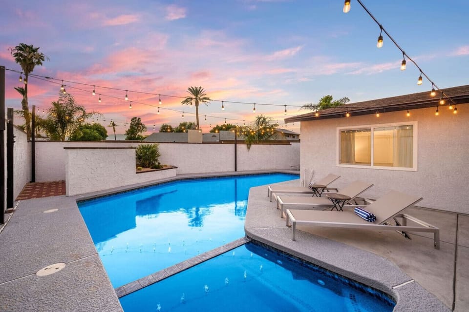 Backyard space: pool/spa, lounge chairs, covered patio, seating area with smart tv, dining table, propane grill, billiards, wood fire pit