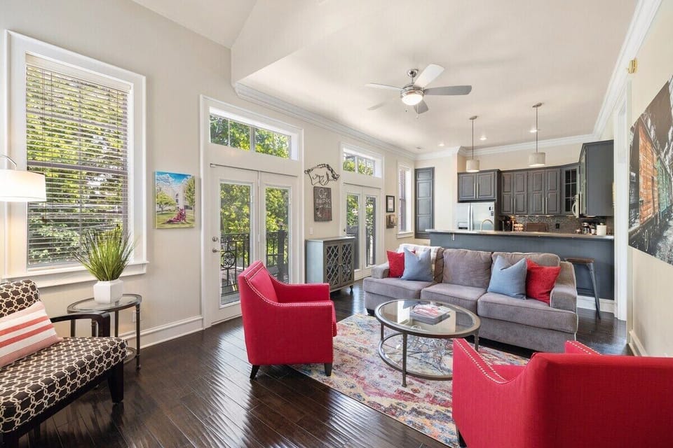 Welcome to the Game Day Getaway! Our spacious living room features large windows and plenty of seating for our guests.