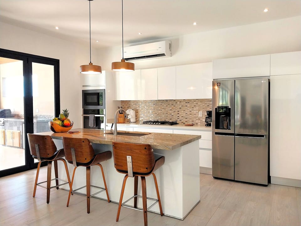 Chef kitchen with oven, dishwasher, gas stove and side-by-side fridge, right next to the outdoor BBQ Area