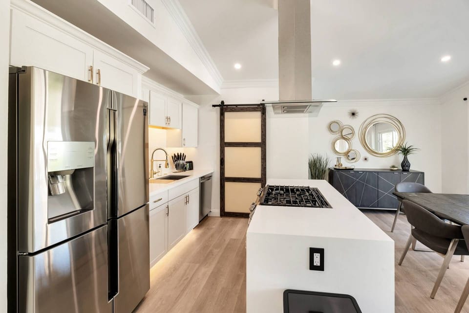 Kitchen features a traditional coffee maker, gas stove, dishwasher, refrigerator