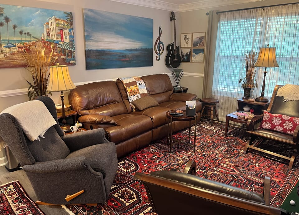 Living room features a 75 inch smart tv w/ 3 recliners & seating for 6