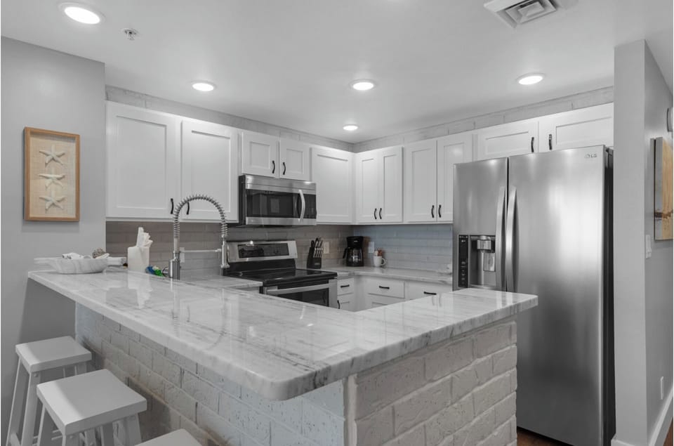 Your modern kitchen features marble countertops, stainless steel appliances, and an island perfect for cooking and casual dining together.