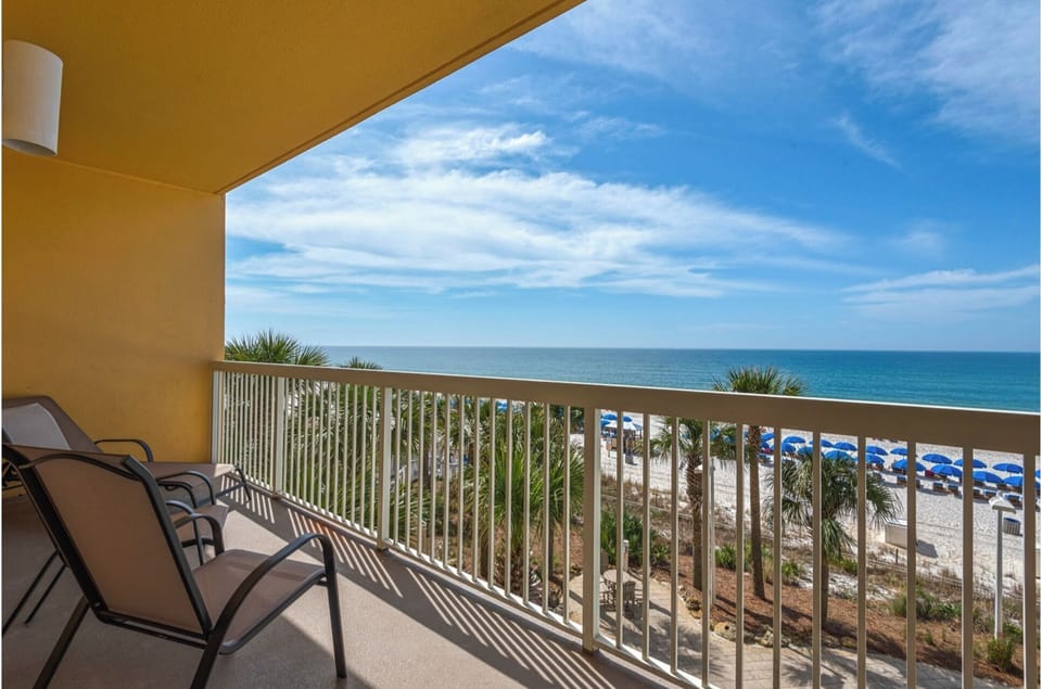 Sip your morning coffee from your private balcony as you watch waves dance across pristine sands and blue umbrellas dot the shoreline below.