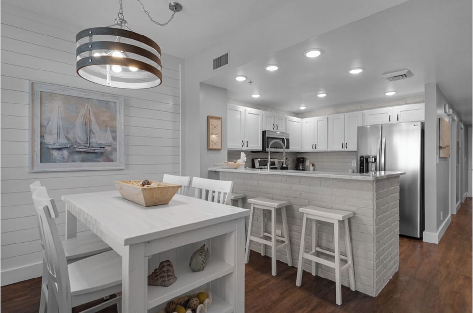 Your bright, coastal-inspired kitchen and dining area features modern appliances and a breakfast bar perfect for morning coffee or casual meals.