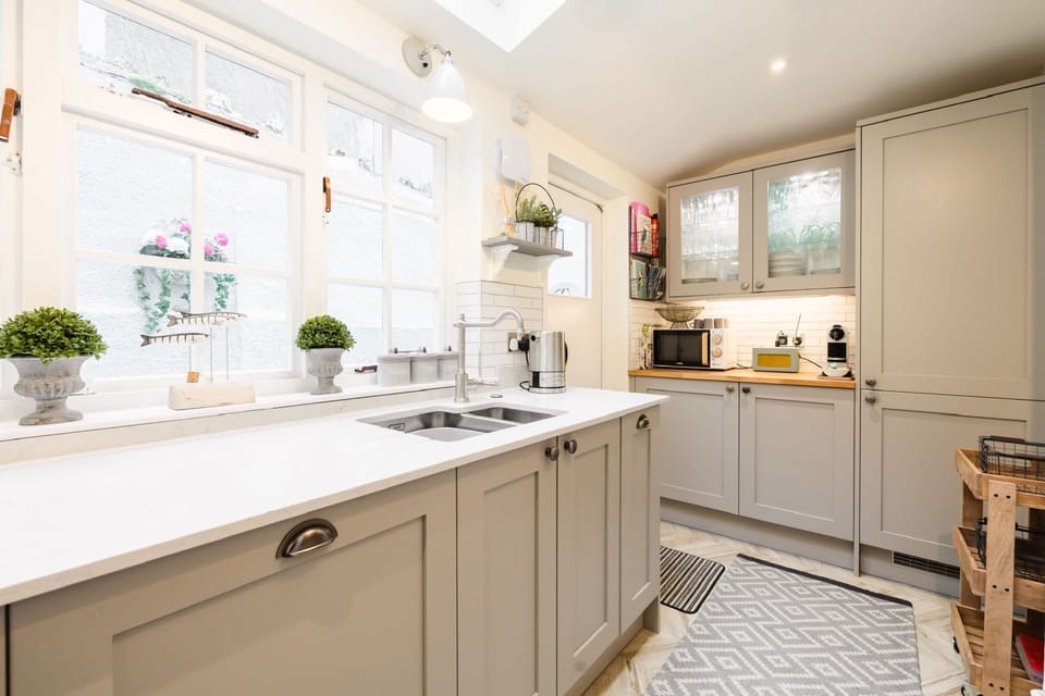 Chart House, Tenby: The well-equipped and bright kitchen with door leading to rear terrace