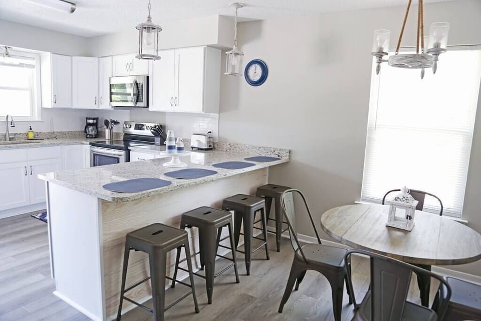 Ample seating for up to 8 guests, including a dining table for four and four bar stools at the counter.