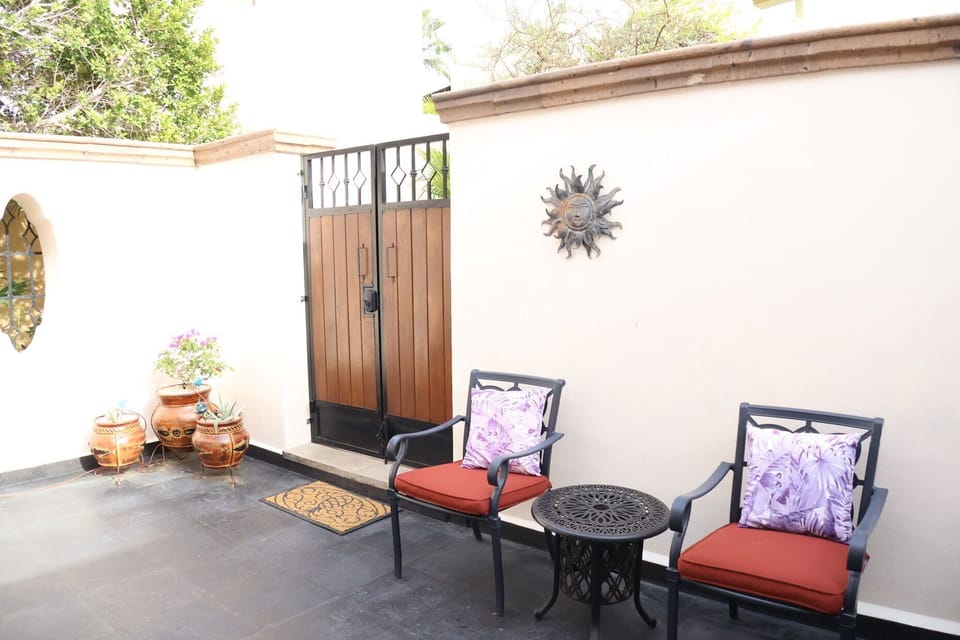Secondary entry/exit via a double gate from newly remodeled private side patio! Relax in peaceful conversation in 2 wrought iron patio chairs and check out the 'hidden' ice bucket inside the round table for your favorite bottled beverages!!