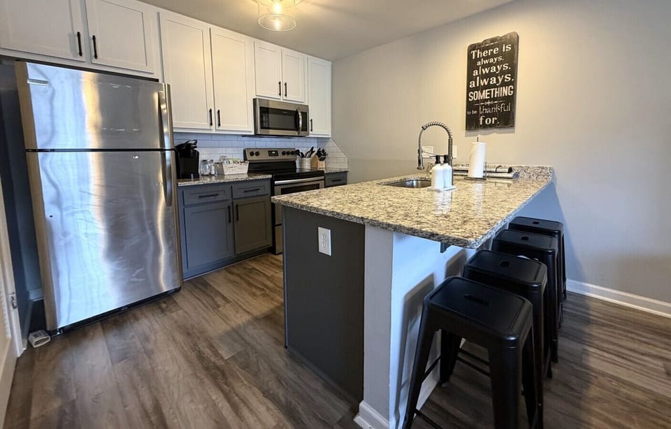 Modern kitchen with oversized island seating — perfect for meals, coffee, or gathering together.