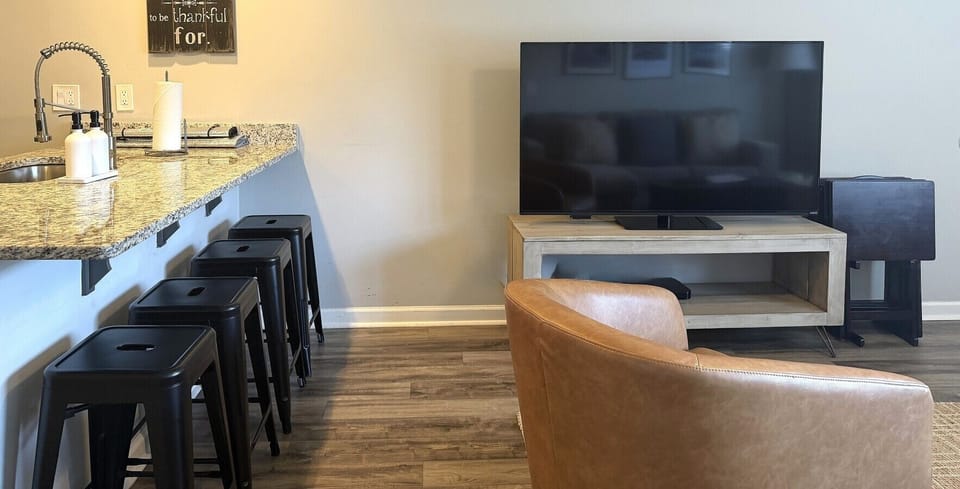 Relax in the open-concept living area with a Smart TV and spacious kitchen island with bar seating.