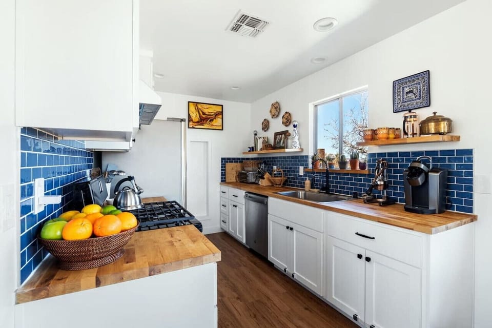 Fully equipped kitchen blends style and function with sleek wood countertops, bold blue tiles, and everything you need for a seamless cooking experience!