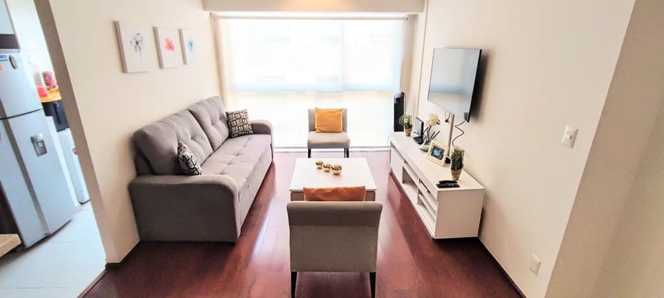 The living room features a spacious layout with ample seating for you and your guests. A large, comfortable sofa and cozy chairs are arranged around a central coffee table, creating a perfect gathering area. 