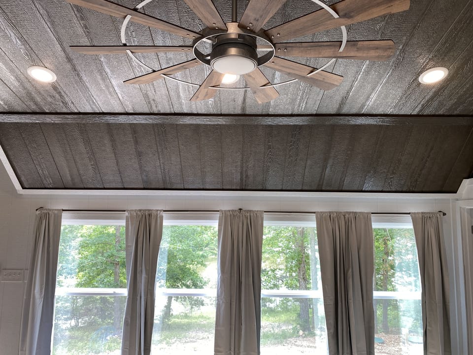 Wood stained ceiling with big ceiling fan.