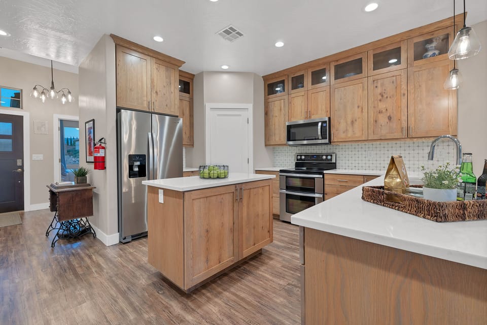 The upstairs kitchen has a four-burner range, refrigerator, dishwasher and microwave. The kitchen is stocked with many small appliances, dishes and utensils.