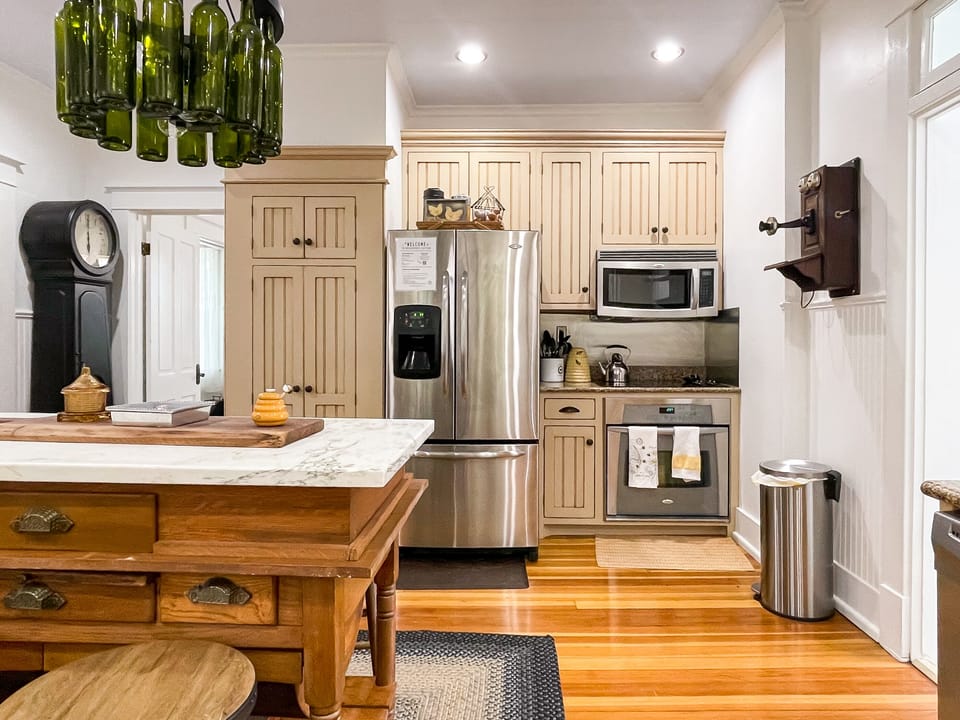 The beautifully detailed full kitchen with modern amenities to enjoy prepping meals for your family/coworkers/friends and eclectic lighting made from wine bottles at The Beekeeper' Cottage.