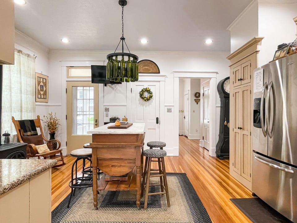The beautifully detailed full kitchen with modern amenities to enjoy prepping meals for your family/coworkers/friends and eclectic lighting made from wine bottles at The Beekeeper' Cottage.