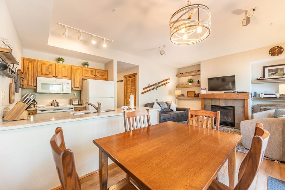 Gather around your spacious dining table while the chef prepares meals in the open kitchen with warm wood finishes.