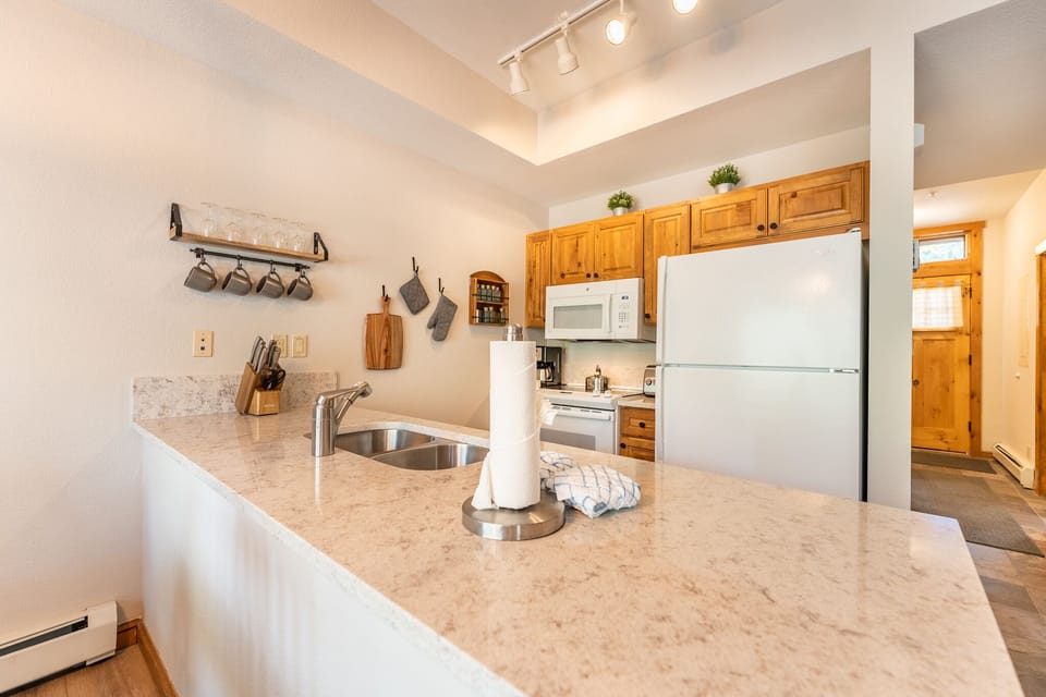 Your fully equipped kitchen features granite countertops, stainless appliances, and warm wood cabinetry—perfect for preparing meals during your stay.
