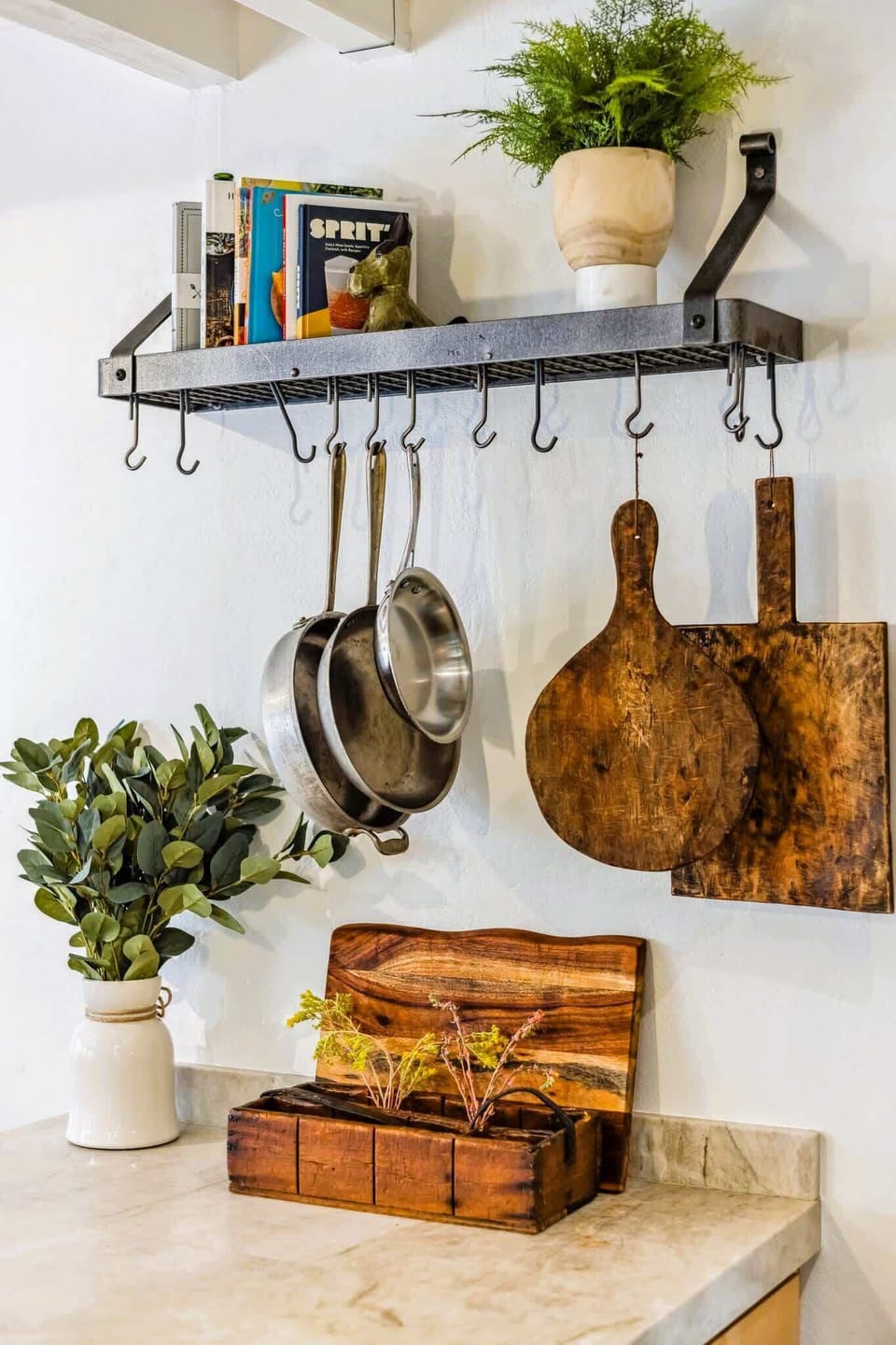 Thoughtfully styled kitchen nook with hanging cookware, cutting boards, and warm details that add charm and function.
