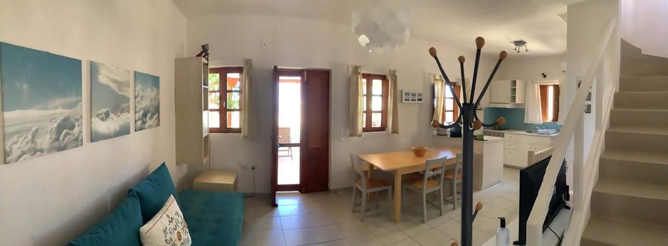 PANORAMIC VIEW OF THE LIVING ROOM AND THE STAIRCASE THAT LEADS UP TO THE BEDROOM