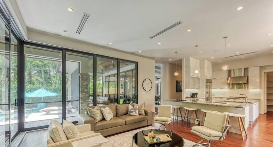 Family Room with 70” Samsung Smart TV, Open layout off Kitchen, Triple Sliding Doors to Patio/Backyard/Pool Area.