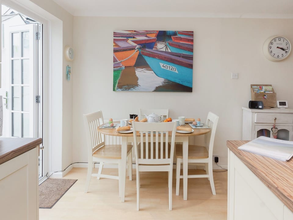 Dining table and chairs with door to patio garden | Kings Cottages 9, Salcombe