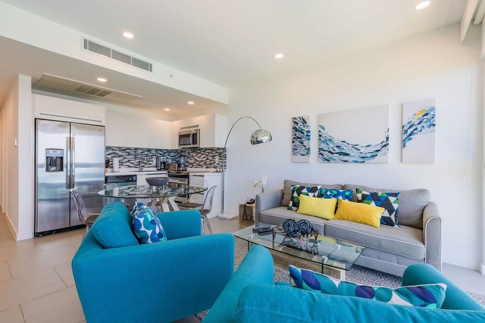 Settle into your bright, open living space where turquoise furnishings and coastal artwork create a breezy, beach-inspired retreat for memorable getaways.