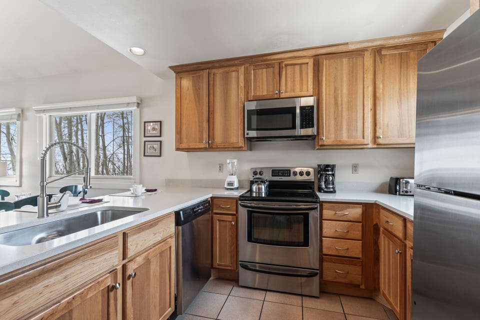 Premier Snow Flower Condominium 130's open concept kitchen with stainless steel appliances.