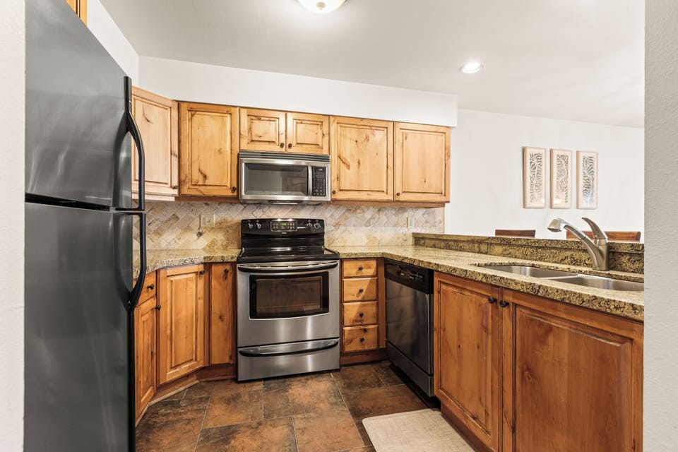 Snow Flower 149 offers a fully equipped kitchen with wood cabinets, granite countertops, and stainless steel appliances.