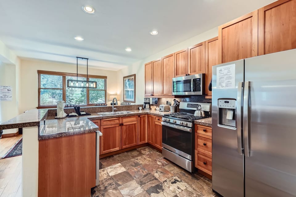 Your fully-equipped gourmet kitchen awaits with rich wood cabinets, granite countertops, and stainless steel appliances - perfect for creating memorable meals during your stay.