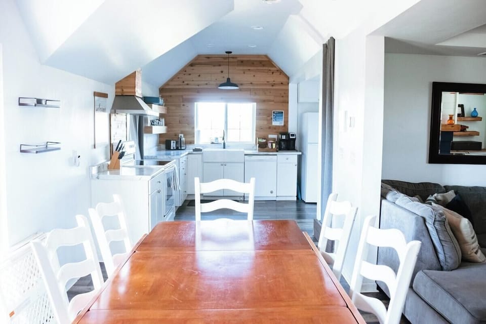 The dining room table comfortably seats six as pictured. There's an additional leaf underneath the table that can expand for larger groups.