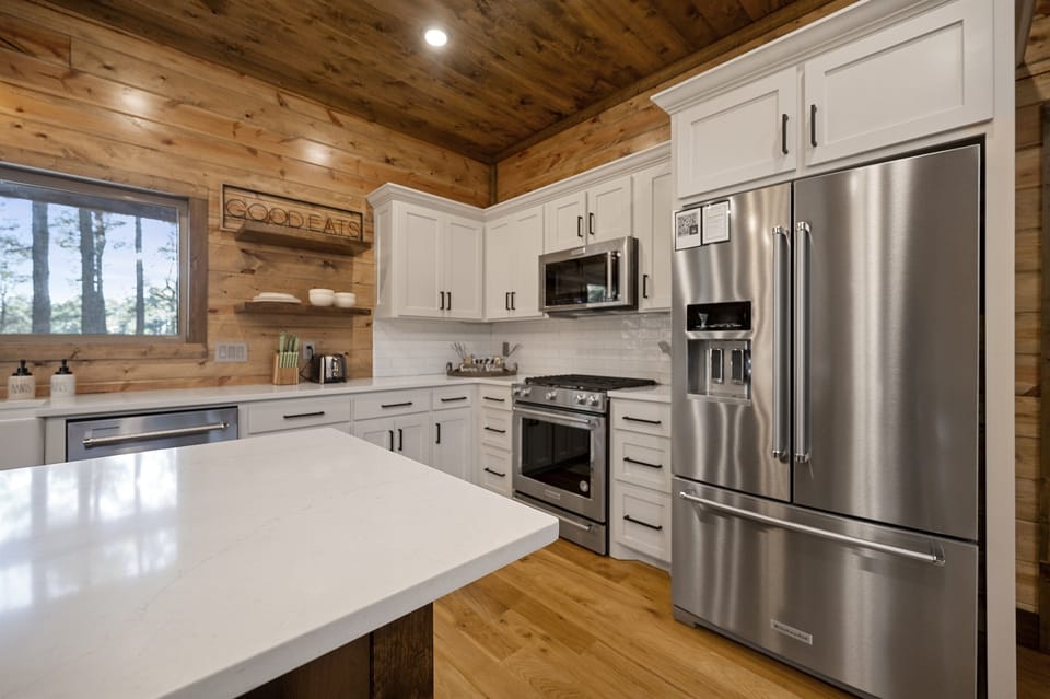 Bright, open kitchen with plenty of prep space and view of the surrounding trees.