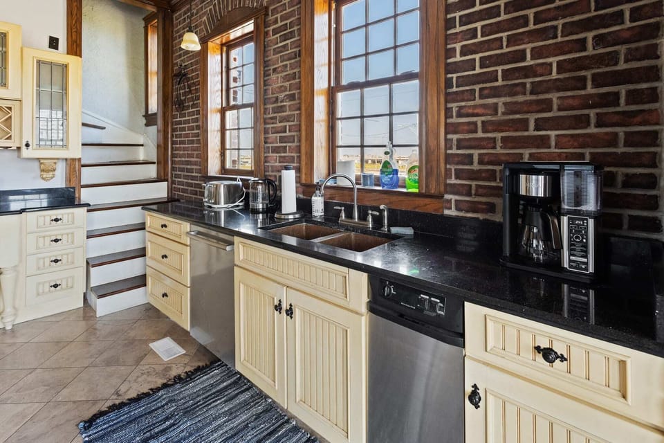 Eat-in kitchen with side-by-side refrigerator, dual oven, gas range, new Bosch dishwasher, and unique copper sink
