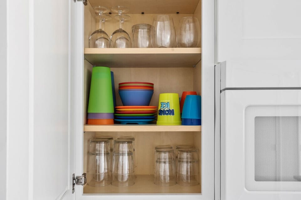 Well stocked cupboards with kids plates and cups too
