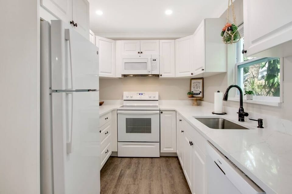 Fully stocked kitchen: pots/pans, dishes & keurig with coffee, creamers & sugar.