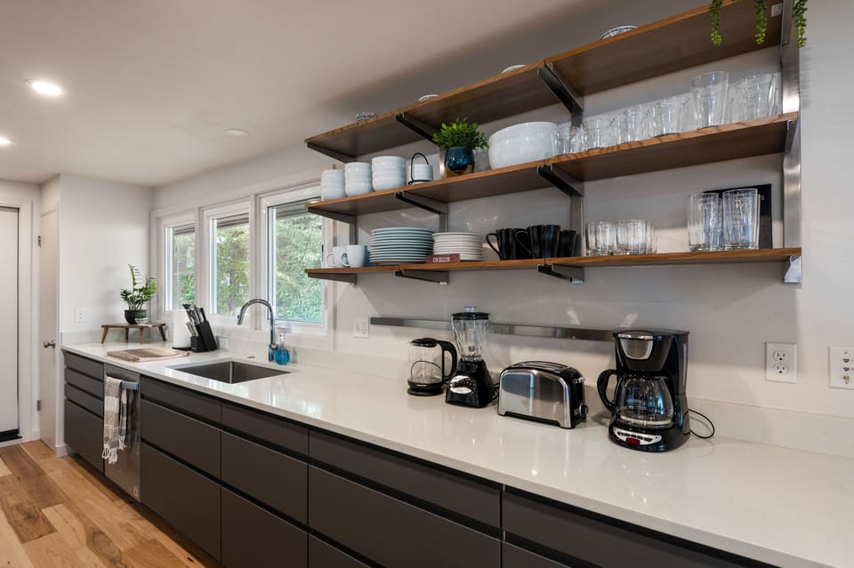 Modern kitchen with open shelves, appliances and dishwasher