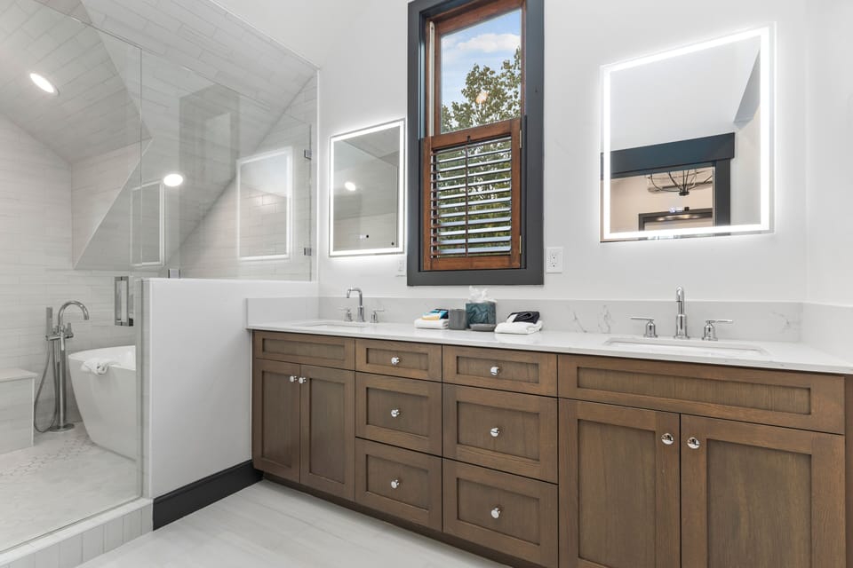 Indulge in our luxurious dual-vanity bathroom, featuring sleek finishes, a spacious walk-in shower, and ample counter space. Your modern spa retreat awaits in Park City.