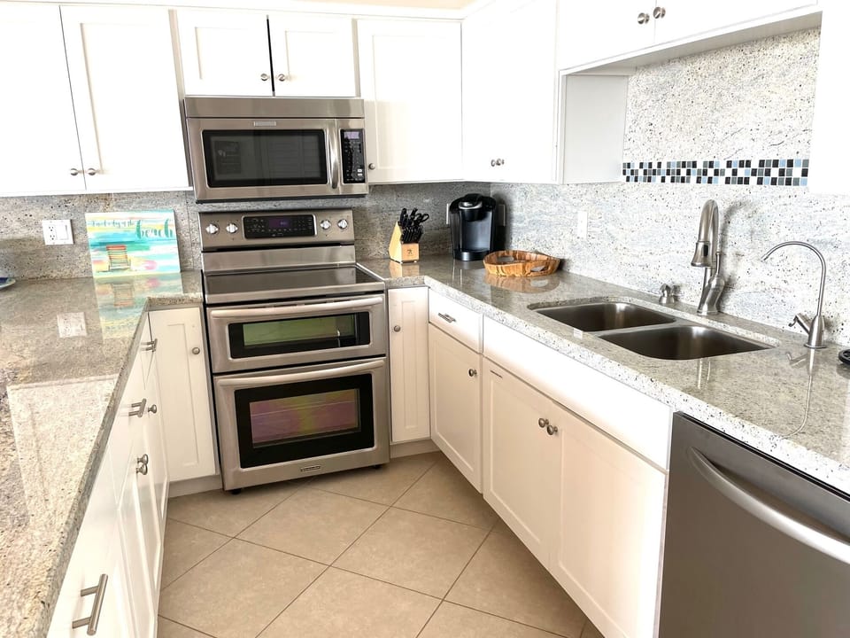 Fully Equipped Kitchen with a granite counter top and backsplash.