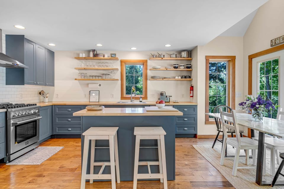 Sunday River gourmet kitchen: gas range, butcher block island & forest views.