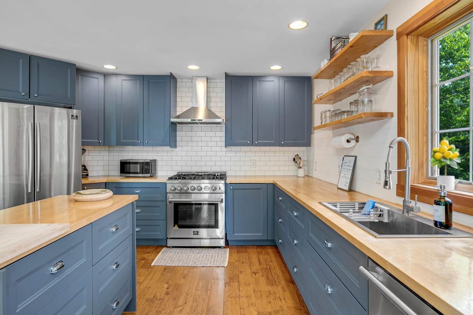 Gourmet Sunday River kitchen: gas range, blue/gray cabinets & farmhouse sink.