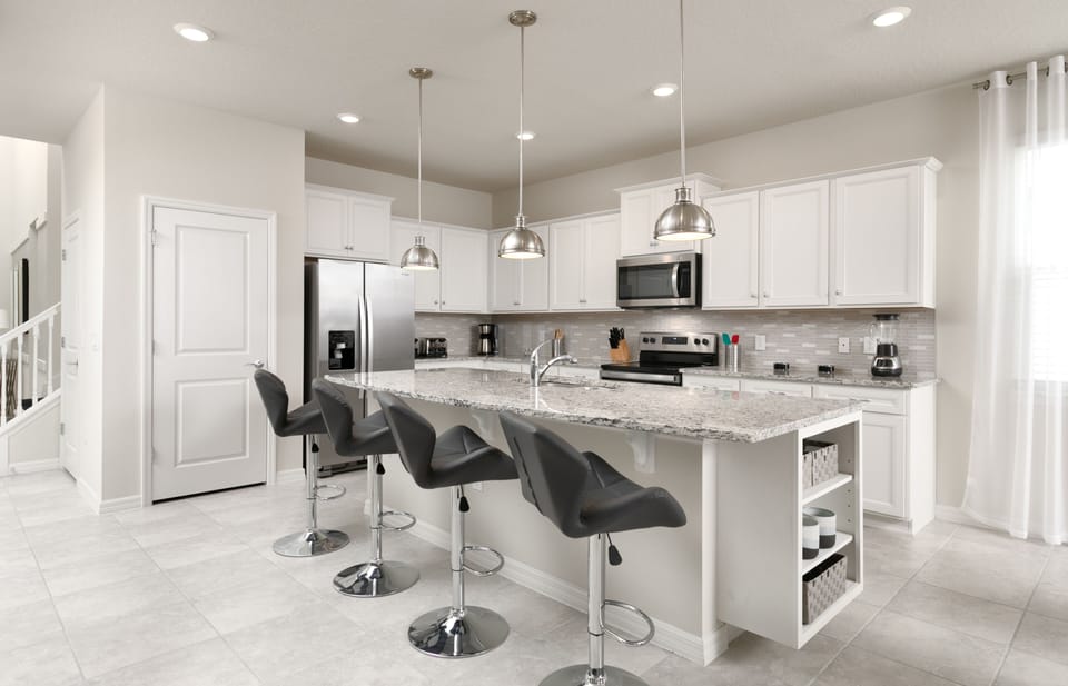 The kitchen has an American-style counter with four leather stools.