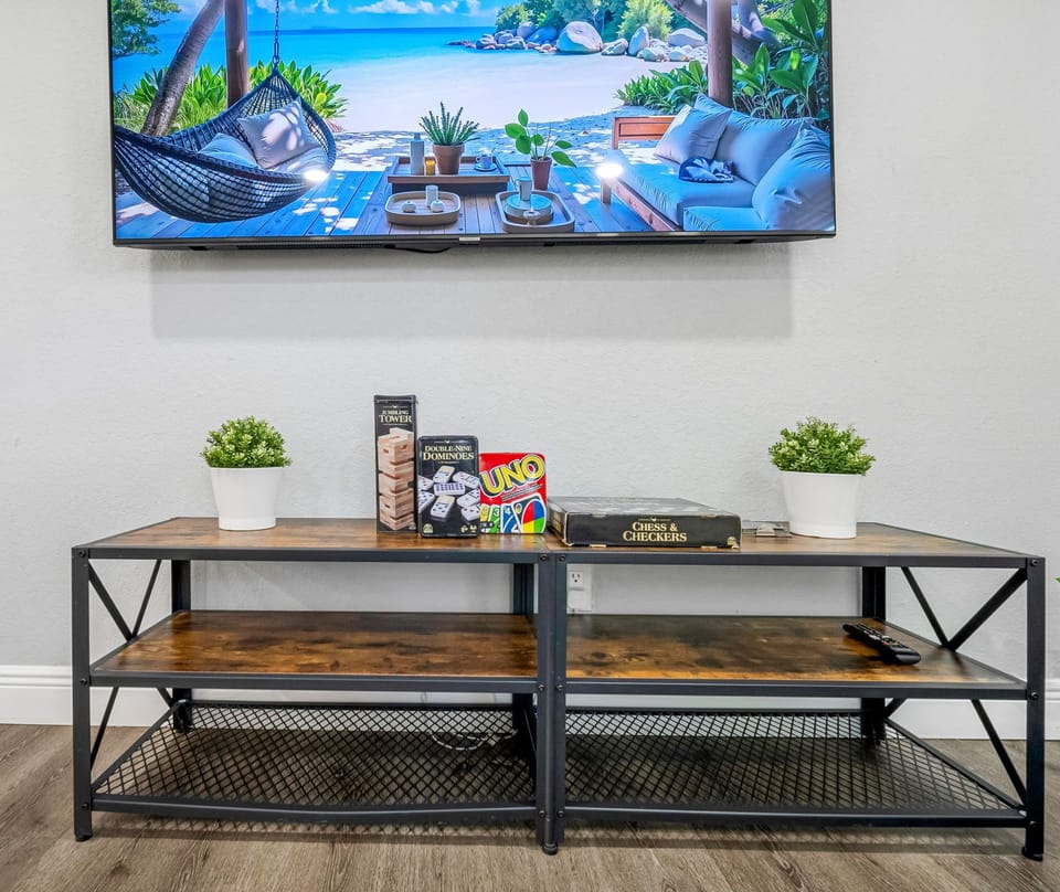 Enjoy movie nights or game time in this stylish setup complete with a flat-screen TV, indoor plants, and classic board games.
