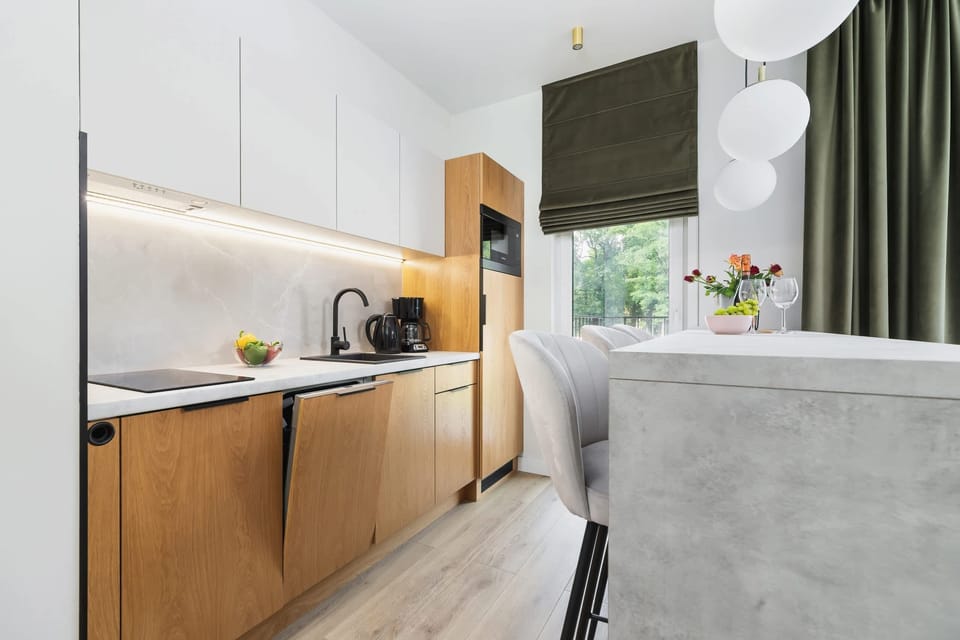 A cozy living area seamlessly connected to a minimalist kitchen, creating a functional and stylish open space.
