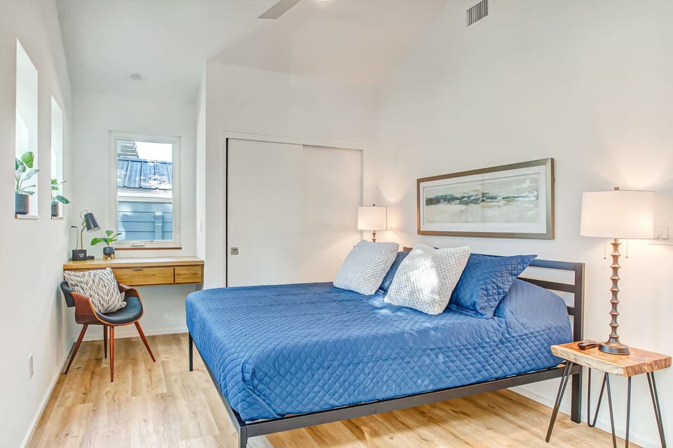 Master bedroom: King bed, smart TV, workspace, and double height ceiling