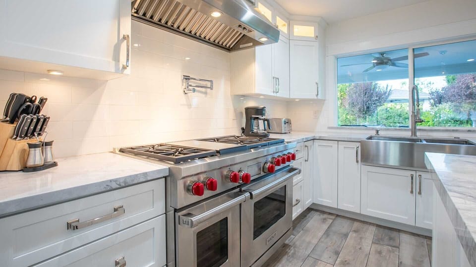 Modern kitchen w/ large gas chefs' stove & farmhouse sink