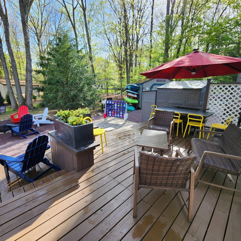 Rear deck with plenty of seating areas, a fire pit, grill and outdoor games.