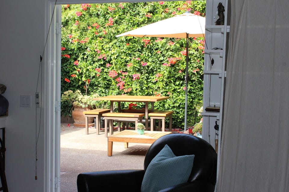 Courtyard dining nestled among sandstone walls, bamboo & flowering trumpet vines