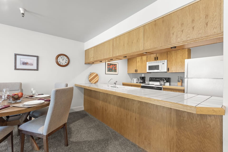 The dining area with seating for 5 guests and kitchen.